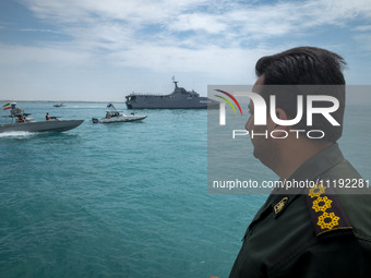 An Islamic Revolutionary Guard Corps (IRGC) Navy military personnel is standing on a warship and monitoring an area during the IRGC marine p...