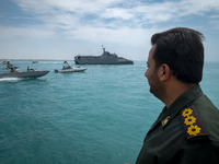 An Islamic Revolutionary Guard Corps (IRGC) Navy military personnel is standing on a warship and monitoring an area during the IRGC marine p...