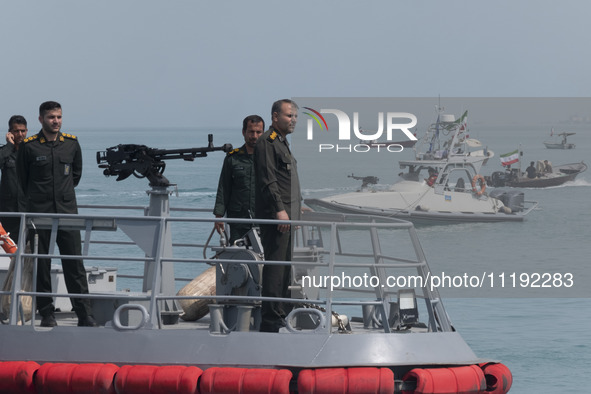 Islamic Revolutionary Guard Corps (IRGC) Navy military personnel are standing on a warship and monitoring an area during the IRGC marine par...