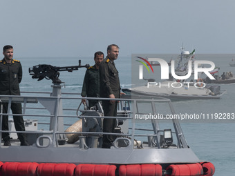 Islamic Revolutionary Guard Corps (IRGC) Navy military personnel are standing on a warship and monitoring an area during the IRGC marine par...