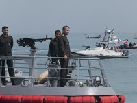 Islamic Revolutionary Guard Corps (IRGC) Navy military personnel are standing on a warship and monitoring an area during the IRGC marine par...