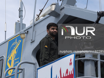 An Islamic Revolutionary Guard Corps (IRGC) Navy military personnel is standing on a warship and monitoring an area during the IRGC marine p...