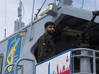 An Islamic Revolutionary Guard Corps (IRGC) Navy military personnel is standing on a warship and monitoring an area during the IRGC marine p...