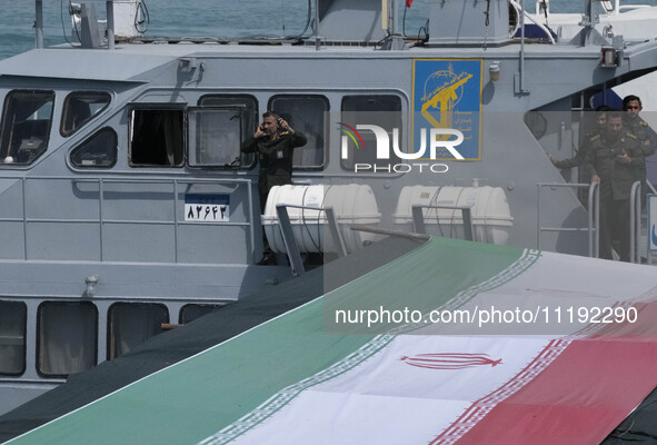 Islamic Revolutionary Guard Corps (IRGC) Navy military personnel are standing on a warship during the IRGC marine parade to commemorate Pers...