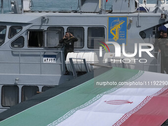 Islamic Revolutionary Guard Corps (IRGC) Navy military personnel are standing on a warship during the IRGC marine parade to commemorate Pers...