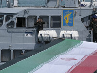 Islamic Revolutionary Guard Corps (IRGC) Navy military personnel are standing on a warship during the IRGC marine parade to commemorate Pers...