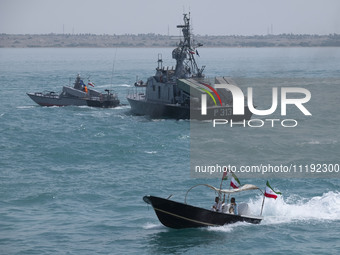 The Islamic Revolutionary Guard Corps (IRGC) Navy Martyr Tavassoli warship is sailing along the Persian Gulf, while a Basij paramilitary for...