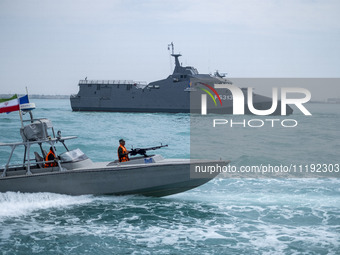 The IRGC Navy Martyr Hassan Bagheri warship and an IRGC speed boat are sailing along the Persian Gulf during the IRGC marine parade, which i...