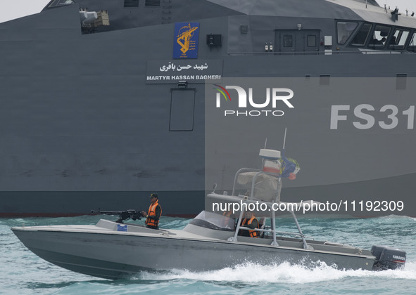 The IRGC Navy Martyr Hassan Bagheri warship and an IRGC speed boat are sailing along the Persian Gulf during the IRGC marine parade to comme...