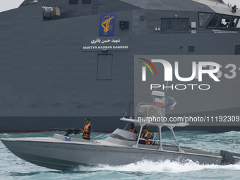 The IRGC Navy Martyr Hassan Bagheri warship and an IRGC speed boat are sailing along the Persian Gulf during the IRGC marine parade to comme...