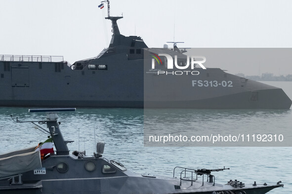 The IRGC Navy Martyr Hassan Bagheri warship and an IRGC speed boat are sailing along the Persian Gulf during the IRGC marine parade, which i...