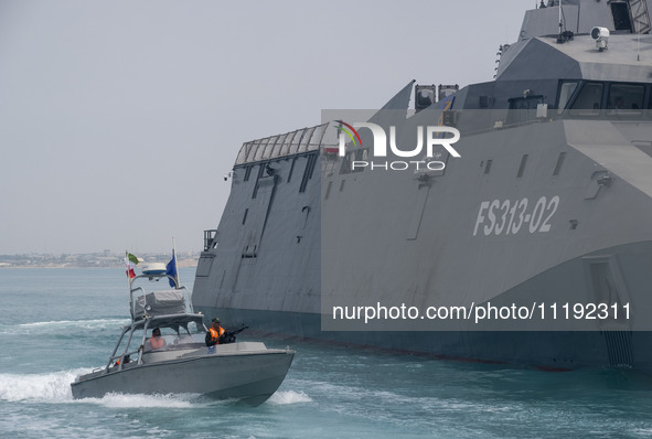 The IRGC Navy Martyr Hassan Bagheri warship and an IRGC speed boat are sailing along the Persian Gulf during the IRGC marine parade in comme...