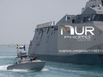 The IRGC Navy Martyr Hassan Bagheri warship and an IRGC speed boat are sailing along the Persian Gulf during the IRGC marine parade in comme...