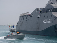 The IRGC Navy Martyr Hassan Bagheri warship and an IRGC speed boat are sailing along the Persian Gulf during the IRGC marine parade in comme...