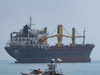 An Islamic Revolutionary Guard Corps (IRGC) speed boat is sailing along the Persian Gulf near a general cargo vessel during the IRGC marine...