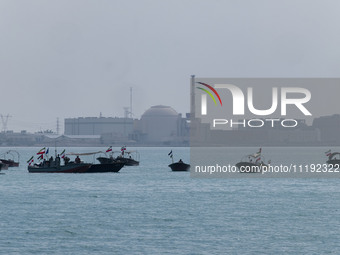 Basij paramilitary force speed boats are sailing along the Persian Gulf near the Bushehr nuclear power plant during the IRGC marine parade c...