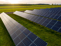 Solar panels on a small solar farm are seen on a field between agricultural produce in a countryside in a village near Sandomierz, Poland on...