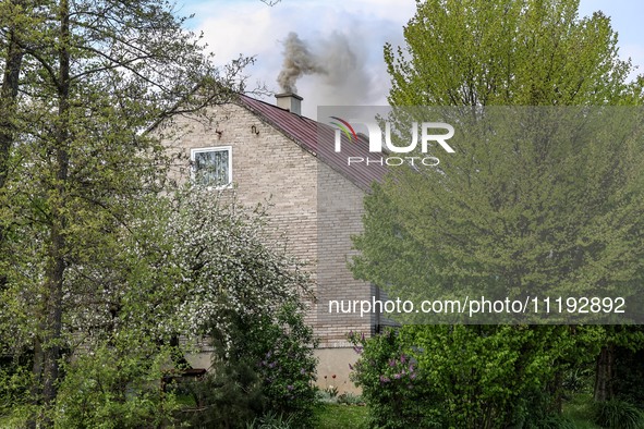 A chimney smoke is seen over a residential house in a village near Sandomierz, central Poland on April 29, 2024. 