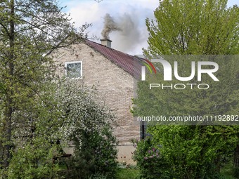 A chimney smoke is seen over a residential house in a village near Sandomierz, central Poland on April 29, 2024. (