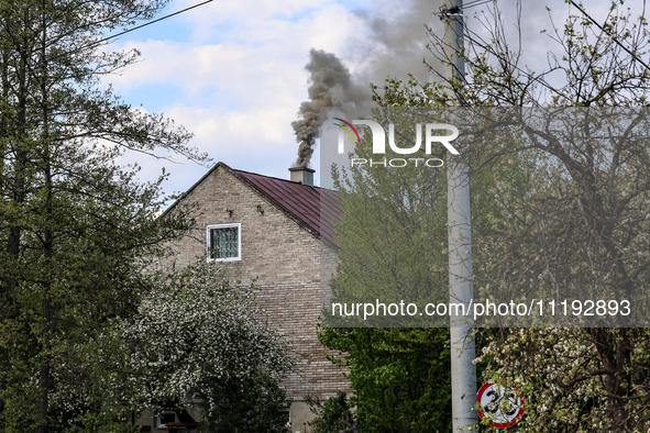 A chimney smoke is seen over a residential house in a village near Sandomierz, central Poland on April 29, 2024. 