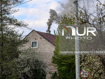 A chimney smoke is seen over a residential house in a village near Sandomierz, central Poland on April 29, 2024. (