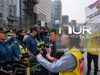 Service Union members are facing police obstruction outside the U.S. Embassy in Seoul, South Korea, on April 30, 2024, as they attempt to de...