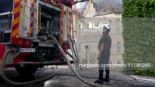 A rescuer is standing by a fire engine outside the Palace of Students of the Odesa Law Academy, which is on fire due to a Russian missile at...