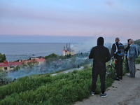 Onlookers are watching the fire at the Palace of Students of the Odesa Law Academy, which was caused by a Russian missile attack in Odesa, U...