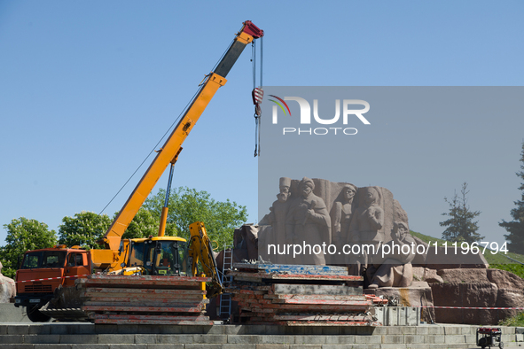 Workers are dismantling the monument commemorating the Pereiaslav Agreement under the Arch of Freedom of the Ukrainian People, formerly know...