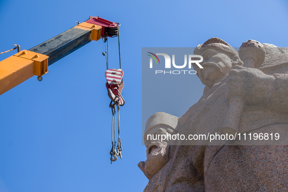 Workers are dismantling the monument commemorating the Pereiaslav Agreement under the Arch of Freedom of the Ukrainian People, formerly know...