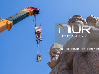 Workers are dismantling the monument commemorating the Pereiaslav Agreement under the Arch of Freedom of the Ukrainian People, formerly know...