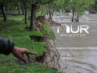 Kashmiri farmers are inspecting their orchards that have been washed away by flash floods in Nathipora Sopore, District Baramulla, Jammu and...