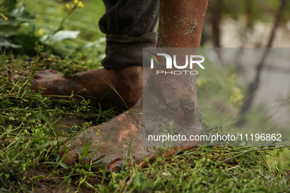 The feet of Ghulam Mohammad, 78, are pictured outside his house, which is submerged due to flash floods on the outskirts of Sopore, District...