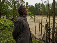 Ghulam Mohammad, 78, is looking towards the river that is causing a flood-like situation outside his house on the outskirts of Sopore, Distr...