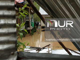 A man is inspecting his house, which is submerged due to flash floods on the outskirts of Sopore, District Baramulla, Jammu and Kashmir, Ind...