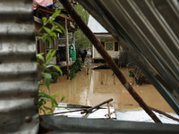 A man is inspecting his house, which is submerged due to flash floods on the outskirts of Sopore, District Baramulla, Jammu and Kashmir, Ind...