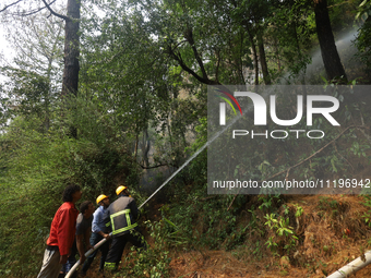 Nepali firefighters are using water cannons to control a blaze that started in a local forest in the Lalitpur District of Central Nepal, on...