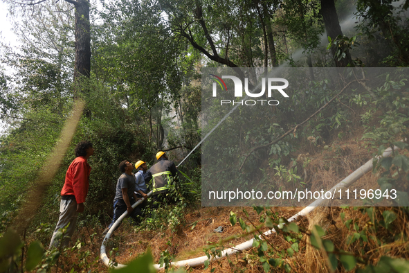 Nepali firefighters are using water cannons to control a blaze that started in a local forest in the Lalitpur District of Central Nepal, on...