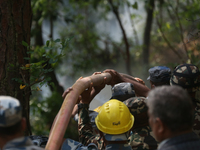 Nepali firefighters from the Nepal Army and Armed Police Force (APF) are holding hoses as they try to control a blaze that started in a loca...