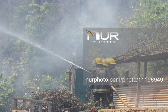 Nepali firefighters are using water cannons to control a blaze that started in a local forest in the Lalitpur District of Central Nepal, on...