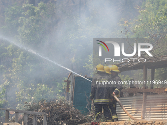 Nepali firefighters are using water cannons to control a blaze that started in a local forest in the Lalitpur District of Central Nepal, on...