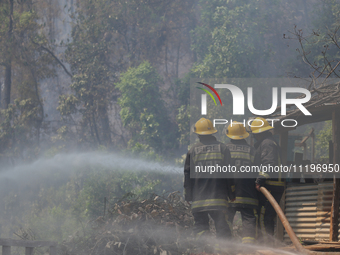 Nepali firefighters are using water cannons to control a blaze that started in a local forest in the Lalitpur District of Central Nepal, on...