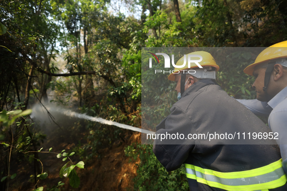 Nepali firefighters are using water cannons to control a blaze that started in a local forest in the Lalitpur District of Central Nepal, on...