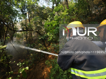 Nepali firefighters are using water cannons to control a blaze that started in a local forest in the Lalitpur District of Central Nepal, on...