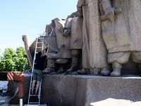 People are taking a photo with dismantled parts of the Soviet monument of friendship between the Ukrainian and Russian peoples in central Ky...