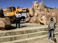 People are taking a photo with dismantled parts of the Soviet monument of friendship between the Ukrainian and Russian peoples in central Ky...