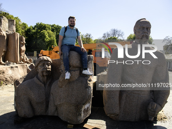 People are taking a photo with dismantled parts of the Soviet monument of friendship between the Ukrainian and Russian peoples in central Ky...