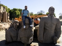 People are taking a photo with dismantled parts of the Soviet monument of friendship between the Ukrainian and Russian peoples in central Ky...