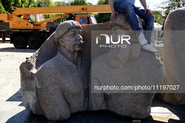 People are taking a photo with dismantled parts of the Soviet monument of friendship between the Ukrainian and Russian peoples in central Ky...