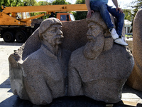 People are taking a photo with dismantled parts of the Soviet monument of friendship between the Ukrainian and Russian peoples in central Ky...